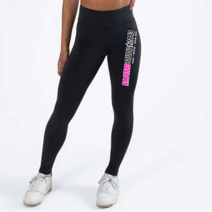 Woman wearing black leggings with branding and a white sports bra on a white background