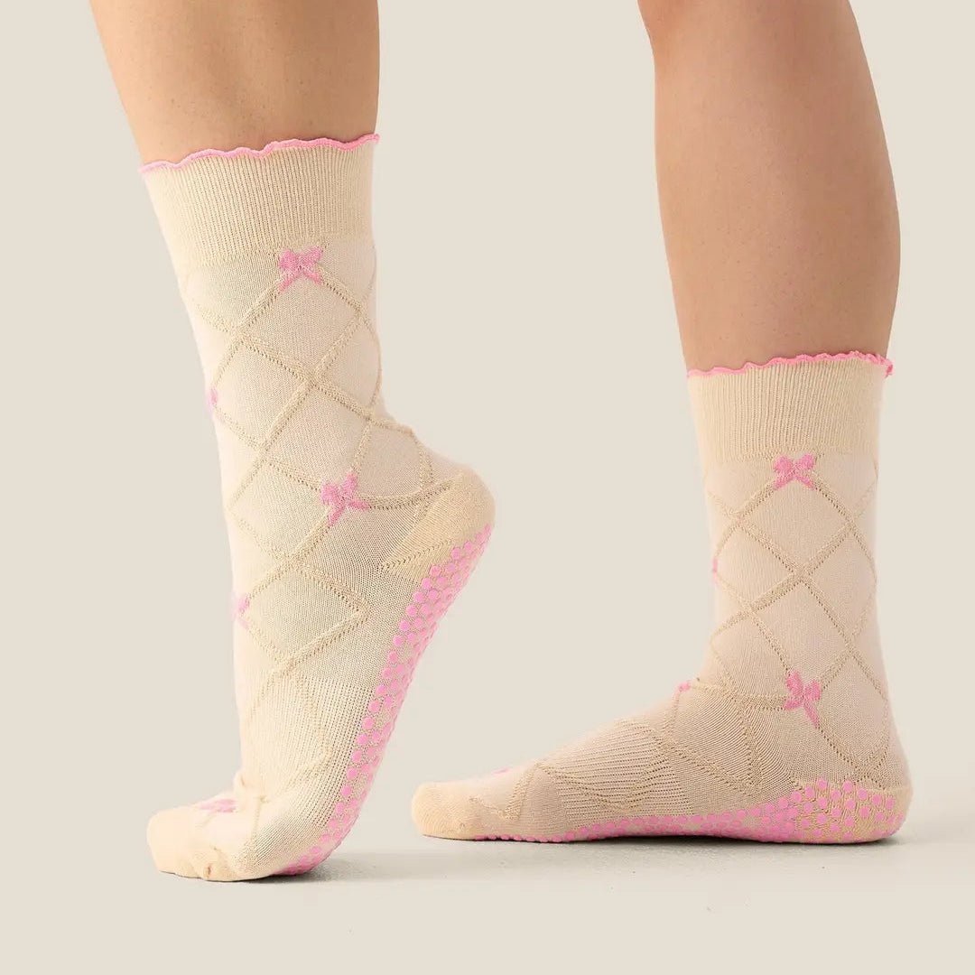 Beige socks with pink accents worn by a person on a neutral background