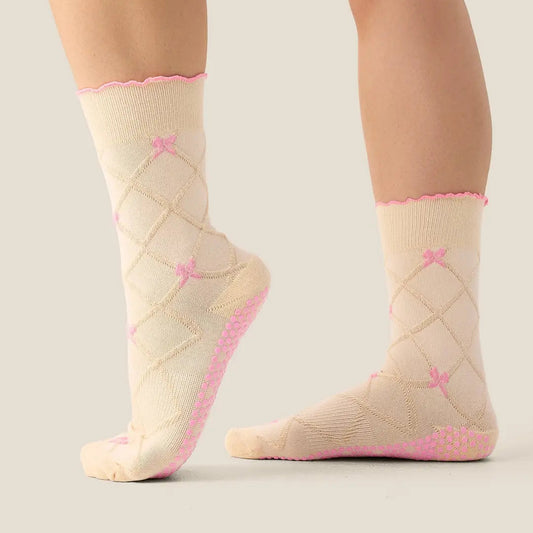 Beige socks with pink accents worn by a person on a neutral background