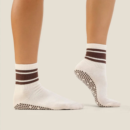 White socks with brown stripes and textured sole on a neutral background