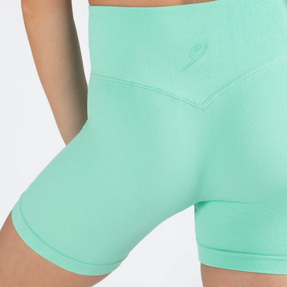 Mint green athletic shorts worn by a person on a light gray background