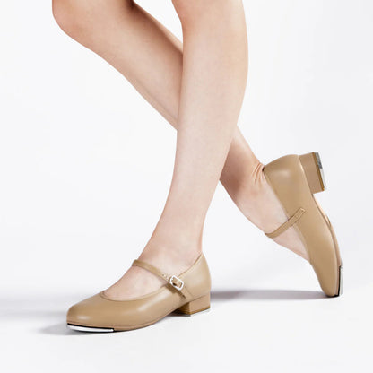 Beige tap shoes worn with white tights on a light background