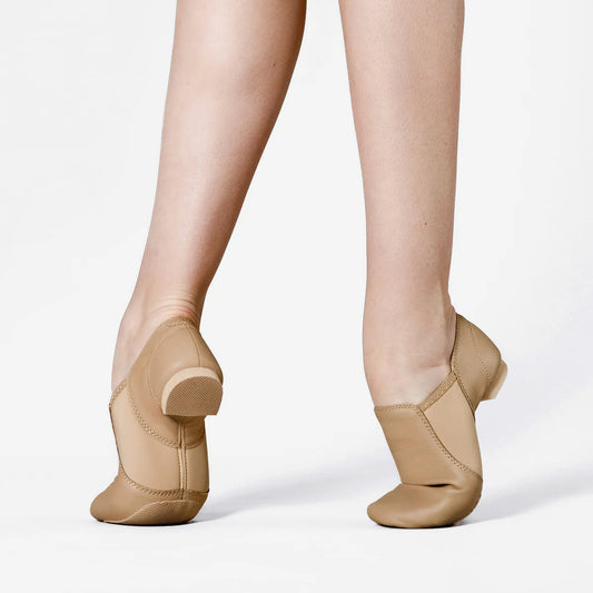 Tan jazz shoes worn on a white background