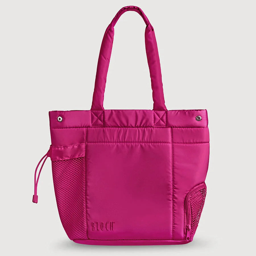 A bright pink puffy tote bag with dual top handles, a front zip pocket, mesh side pockets, and a drawstring detail, shown against a light gray background.