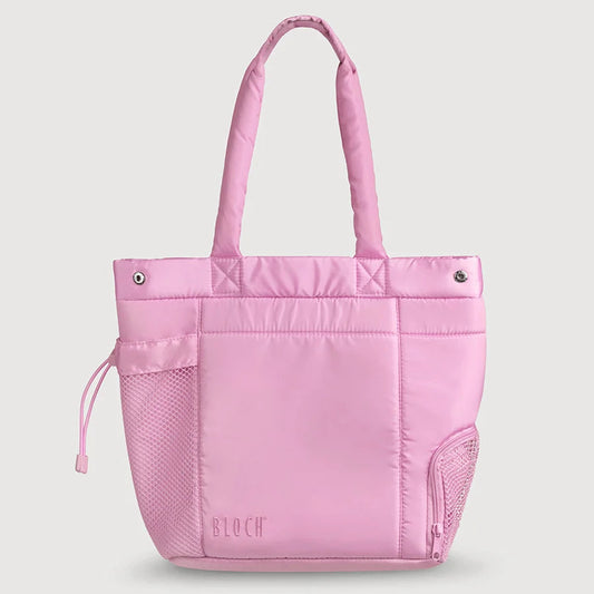 A light pink nylon tote bag with padded handles, a front slip pocket, mesh side pockets, and a subtle 'STOCK' logo printed near the bottom, shown against a solid light gray background.