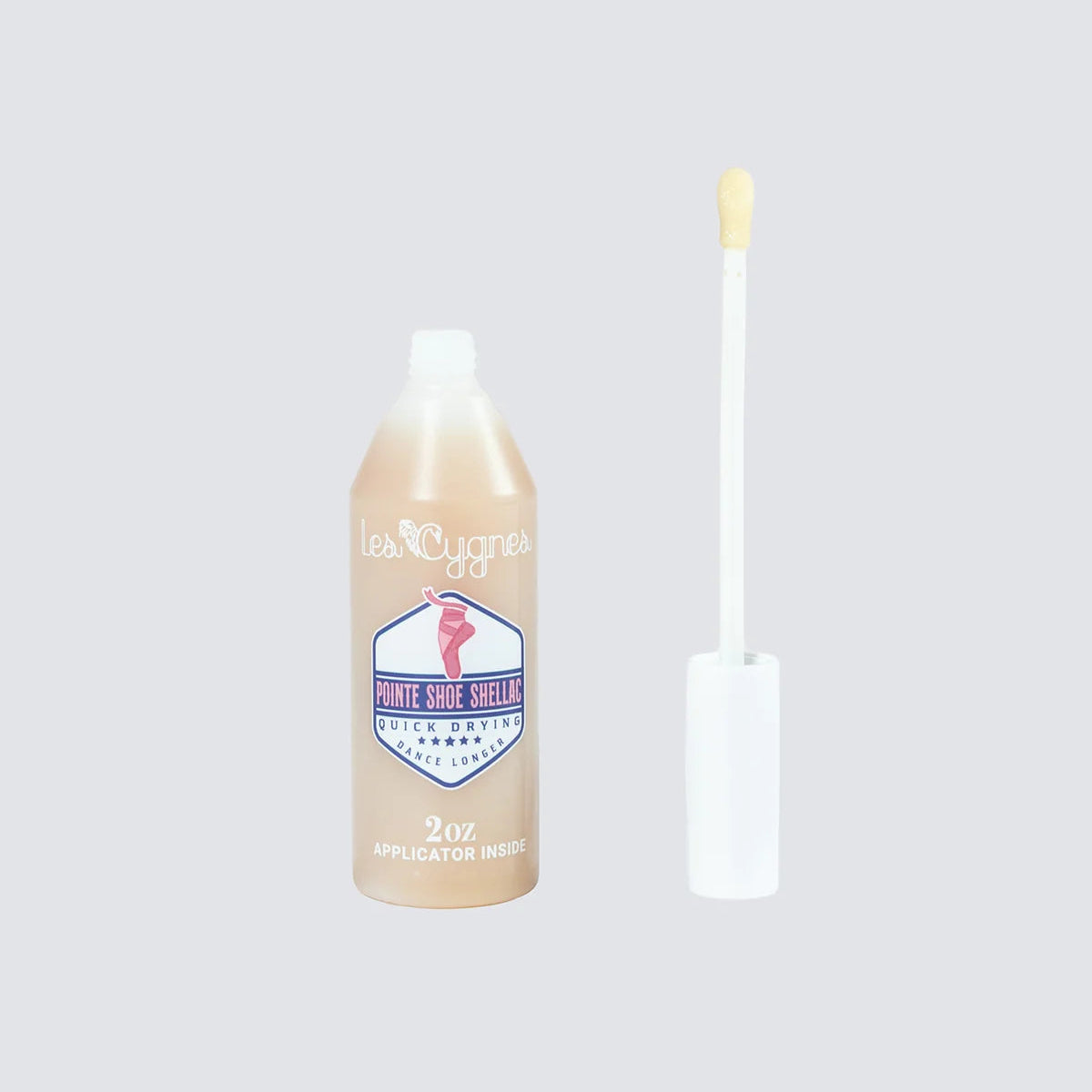 A bottle of Pointe Shoe Shellac by Energetiks with its applicator wand removed and standing beside it on a solid light gray background.